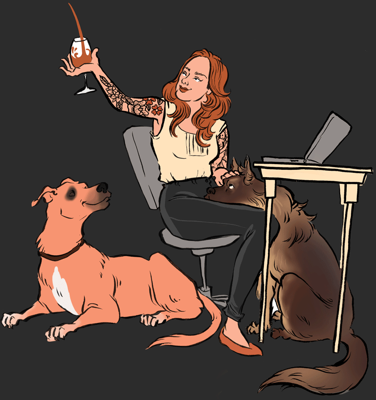 woman sitting in chair at desk with two dogs